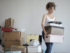 Woman moves boxes as part of an apartment move.
