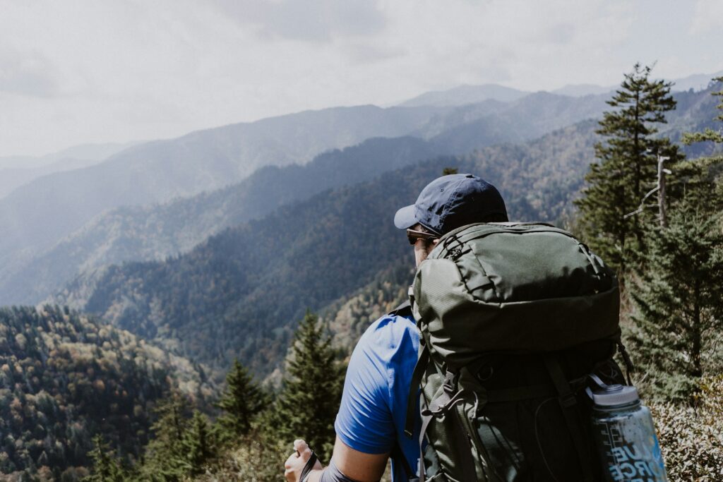 A man with his hiking backpack observing the Great Smoky Mountains