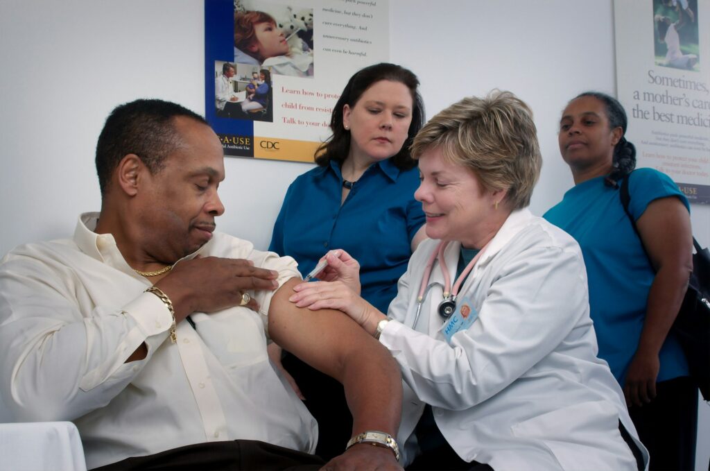 A man getting a vaccine by a lady doctor