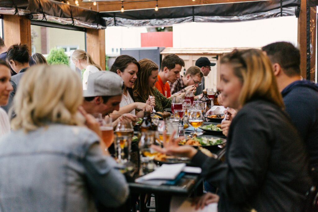 A group of people around a big table enjoying good food and beer