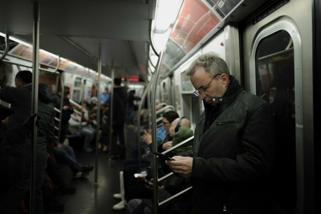 A man looking at his cell in the subway